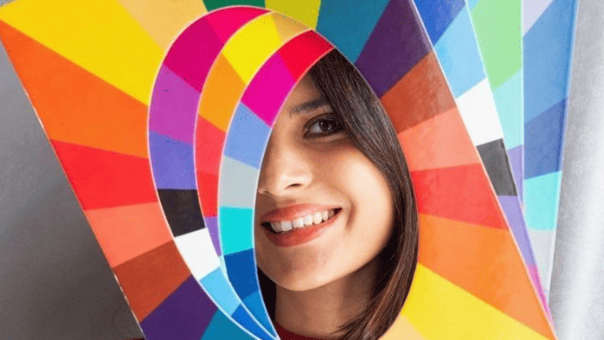 Colorimetría Mujer con carteles de diversos colores, mirando a cámara